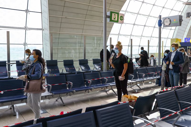 &copy; Reuters. FOTO DE ARCHIVO: Fila de pasajeros con mascarillas guardando la distancia social en el Aeropuerto Internacional de Dubái, Emiratos Árabes Unidos, el 27 de abril de 2020. REUTERS/Ahmed Jadallah