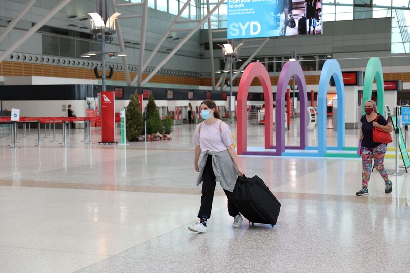 &copy; Reuters. Alcune persone presso il terminal nazionale del Sydney Airport di Sydney, in Australia, il 21 dicembre 2020. REUTERS / Loren Elliott 
