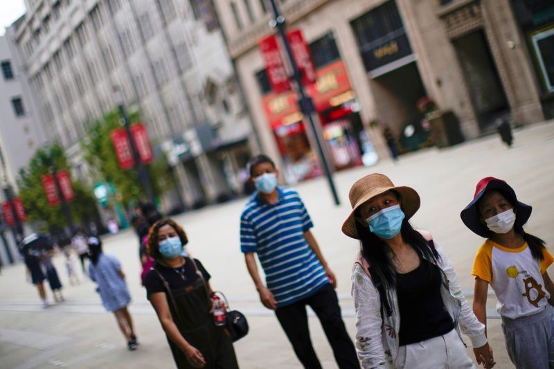 &copy; Reuters. Imagen de archivo de gente usando mascarillas mientras camina en una calle, luego de que se reportaran nuevos casos de COVID-19 en Shanghái, China. 25 de agosto, 2021. REUTERS/Aly Song/Archivo