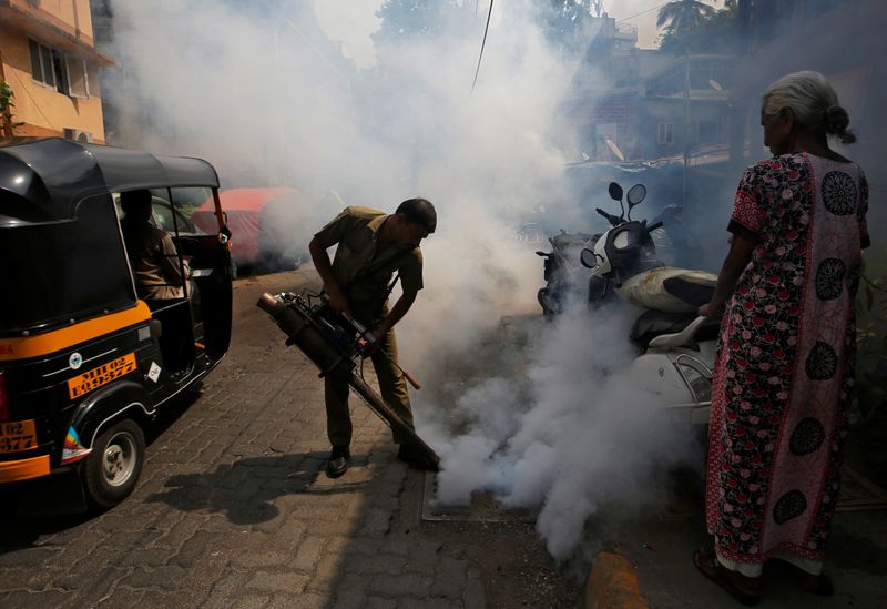 © Reuters. صورة من أرشيف رويترز لعامل في المجال الصحي أثناء حملة لتعقيم الشوارع من حمى الضنك في مومباي.