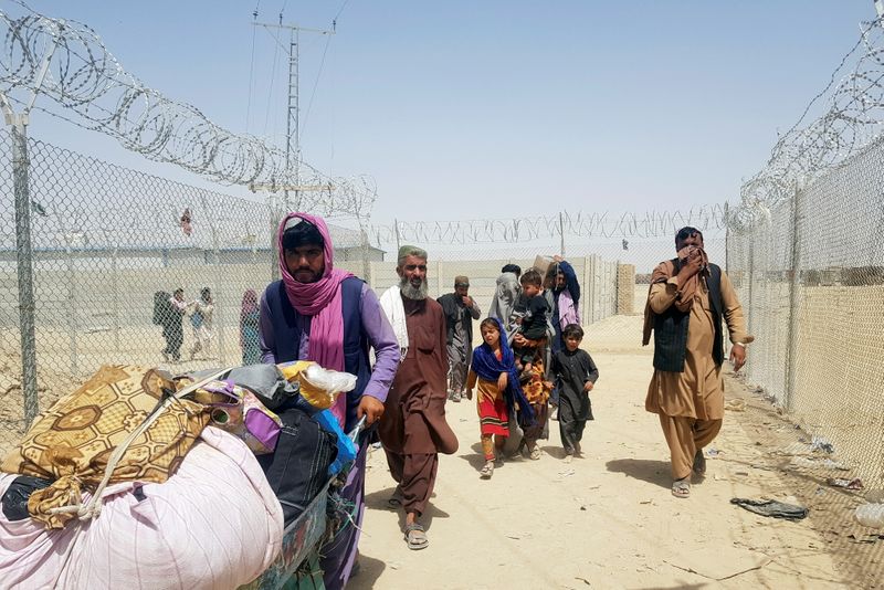 &copy; Reuters. Imagen de archivo de una familia de Afganistán caminando junto a una reja para cruzar a Pakistán en el cruce Puerta de la Amistad en la frontera entre Pakistán y Afganistán, en el pueblo de Chaman, Pakistán. 6 de septiembre, 2021. REUTERS/Abdul Khali
