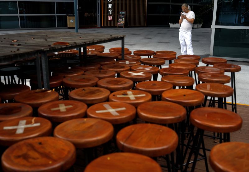 &copy; Reuters. FILE PHOTO: A kitchen assistant takes a break next to an outdoor seating area of a closed restaurant, amid the coronavirus disease (COVID-19) outbreak, in Singapore July 14, 2020. REUTERS/Edgar Su