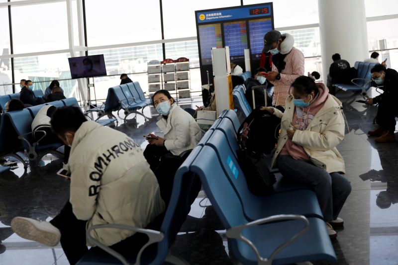 &copy; Reuters. FILE PHOTO: Travellers wait at Wuhan Tianhe International Airport following the coronavirus disease (COVID-19) outbreak in Wuhan, Hubei province, China January 2, 2021. REUTERS/Tingshu Wang/File Photo