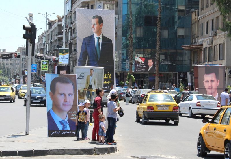 &copy; Reuters. Transeúntes caminan cerca de carteles con la imagen del presidente sirio Bashar al-Assad, Damasco, Siria, 18 mayo 2021.
REUTERS/Firas Makdesi/File Photo