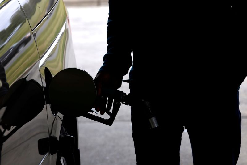 © Reuters. FILE PHOTO: A motorist tops up the fuel in his car's gas tank after a lengthy wait to enter a gasoline station during a surge in the demand for fuel following the cyberattack that crippled the Colonial Pipeline, in Durham, North Carolina, U.S. May 12, 2021.  REUTERS/Jonathan Drake//File Photo