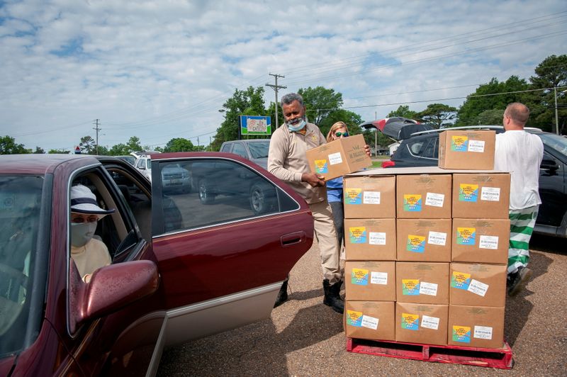 © Reuters. FILE PHOTO: A Quitman County Sheriff’s Department officer distributes food boxes at an aid site in Marks, Mississippi, U.S., May 24, 2021.  REUTERS/Rory Doyle