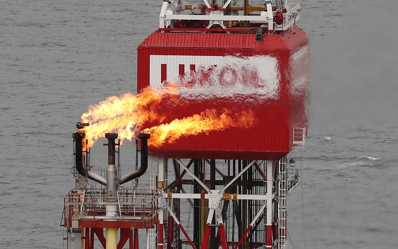 &copy; Reuters. FILE PHOTO: A gas torch is seen next to the Lukoil company sign at the Filanovskogo oil platform in the Caspian Sea, Russia October 16, 2018. REUTERS/Maxim Shemetov/File Photo