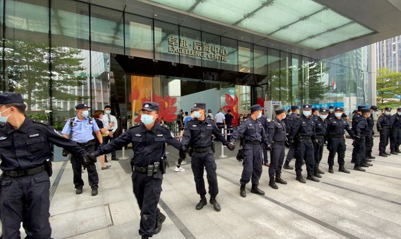 &copy; Reuters. FILE PHOTO: Security personnel form a human chain as they guard outside the Evergrande's headquarters, where people gathered to demand repayment of loans and financial products, in Shenzhen, Guangdong province, China September 13, 2021. REUTERS/David Kirt
