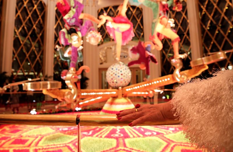 © Reuters. FILE PHOTO: A woman rest next to the decoration inside the Wynn Palace casino resort in Macau, China December 20, 2019, on the 20th anniversary of the former Portuguese colony's return to China. REUTERS/Jason Lee