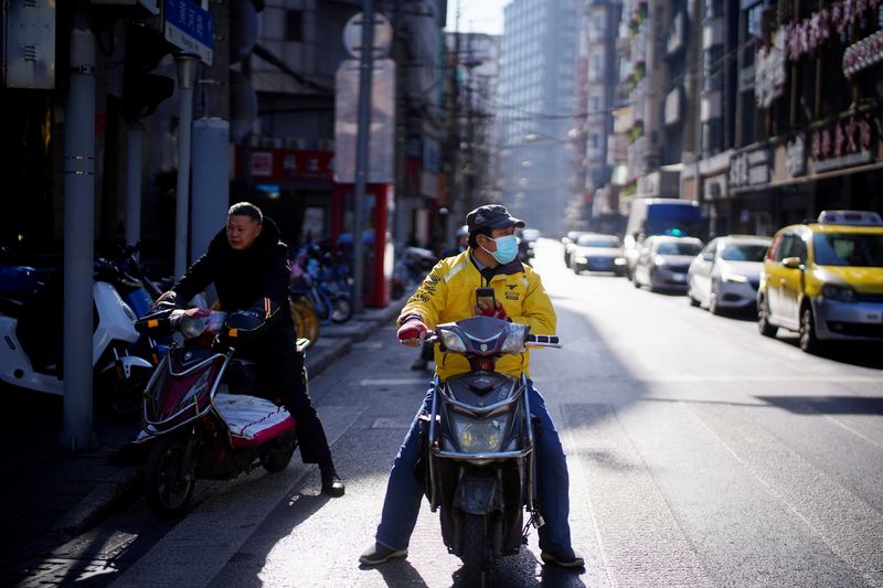 © Reuters. FILE PHOTO: A Meituan delivery worker wearing a mask is seen on a street in Shanghai, China January 13, 2021. REUTERS/Aly Song/File Photo