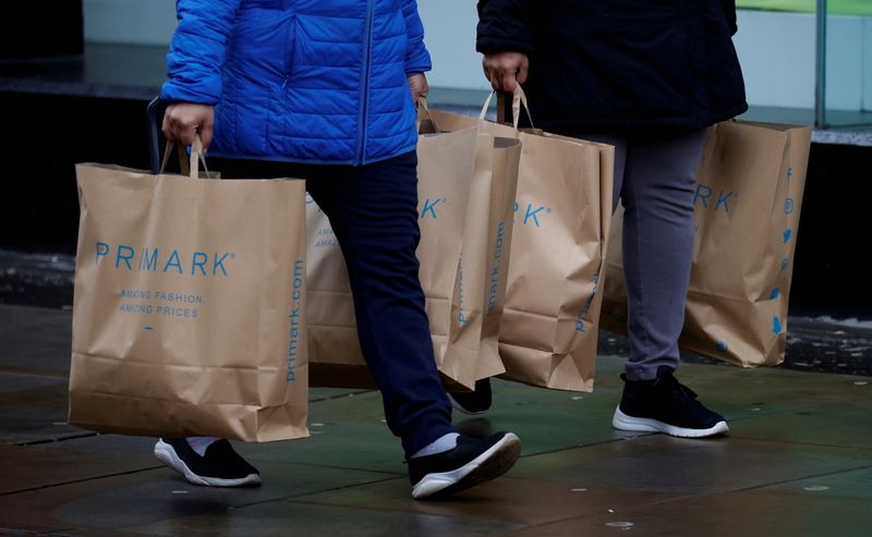 &copy; Reuters. FILE PHOTO: Shoppers carry bags from Primark at the start of the Boxing Day sales amid the outbreak of the coronavirus disease (COVID-19) in Manchester, Britain, December 26, 2020. REUTERS/Phil Noble