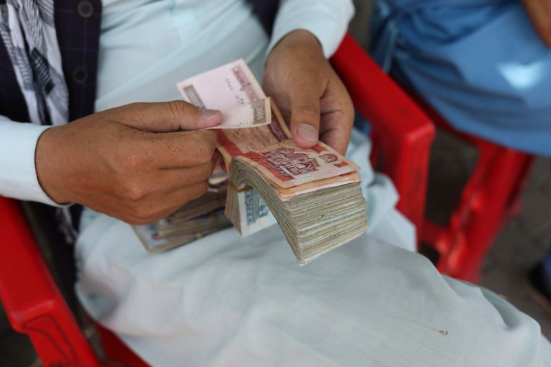 &copy; Reuters. FILE PHOTO: An Afghan man counts his money after the Afghan currency faced devaluation in Kabul, Afghanistan, September 4, 2021. WANA (West Asia News Agency) via REUTERS 
