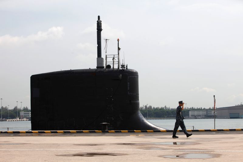 © Reuters. FILE PHOTO: A U.S. Navy personel walks past the USS North Carolina (SSN-777) submarine docked at Changi Naval Base in Singapore April 28, 2014. The U.S. Navy Virginia-class nuclear submarine arrived in Singapore April 26 for a routine visit as part of its second deployment to the Western Pacific. REUTERS/Edgar Su