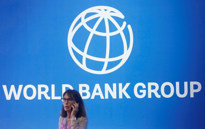 &copy; Reuters. امرأة تقف أمام شعار مجموعة البنك الدولي - صورة من أرشيف رويترز 