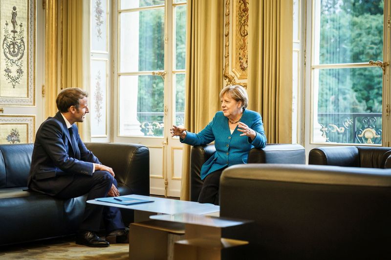 © Reuters. ماكرون يتحدث مع ميركل في قصر الإليزيه في باريس يوم الخميس. صورة لرويترز ومحظور أعادة بيعها أو وضعها في الأرشيف