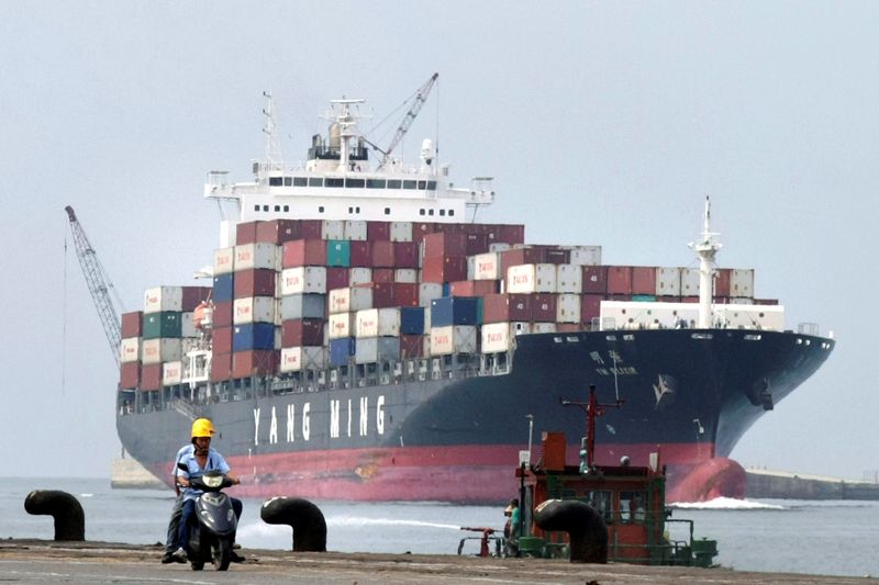 &copy; Reuters. People ride a motorcycle while a container ship passes by at Keelung port in northern Taiwan July 20, 2010.   REUTERS/Pichi Chuang/File Photo 