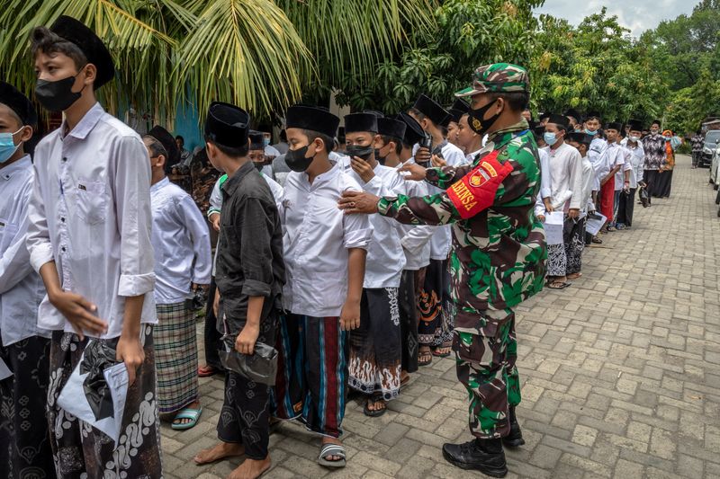 &copy; Reuters. Des élèves font la queue pour recevoir une dose de vaccin contre le coronavirus lors d'un programme de vaccination de masse dans un internat à Demak, dans la province de Central Java, en Indonésie.  La directrice générale du Fonds monétaire interna