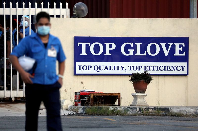 &copy; Reuters. FILE PHOTO: A worker leaves a Top Glove factory after his shift in Klang, Malaysia Dec. 7, 2020. REUTERS/Lim Huey Teng/File Photo