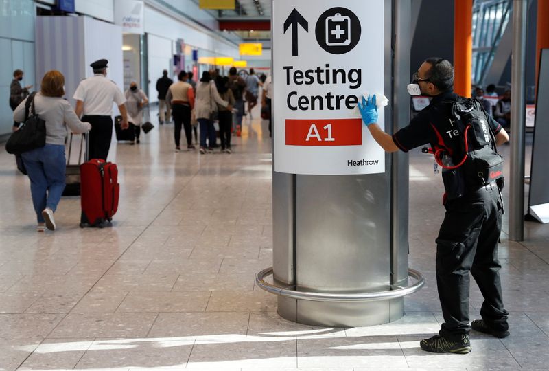 &copy; Reuters. A worker sanitises a sign at the International arrivals area of Terminal 5 in London's  Heathrow Airport, Britain, August 2, 2021.  REUTERS/Peter Nicholls/Files