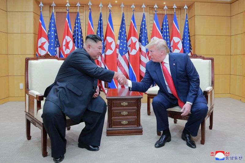&copy; Reuters.  كيم جونج أون زعيم كوريا الشمالية يصافح الرئيس الأمريكي السابق دونالد ترامب أثناء اجتماع بينهما في المنطقة منزوعة السلاح على الحدود بين الك