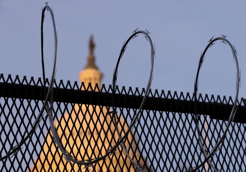 &copy; Reuters. FILE PHOTO: Newly-installed razor wire tops the unscalable fence surrounding the U.S. Capitol in the wake of the January 6th riot and ahead of the upcoming inauguration in Washington, U.S. January 14, 2021. REUTERS/Jonathan Ernst/File Photo