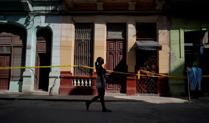 &copy; Reuters. FILE PHOTO: A woman walks past houses in quarantine amid concerns about the spread of the coronavirus disease (COVID-19), in Havana, Cuba, April 8, 2021. REUTERS/Alexandre Meneghini