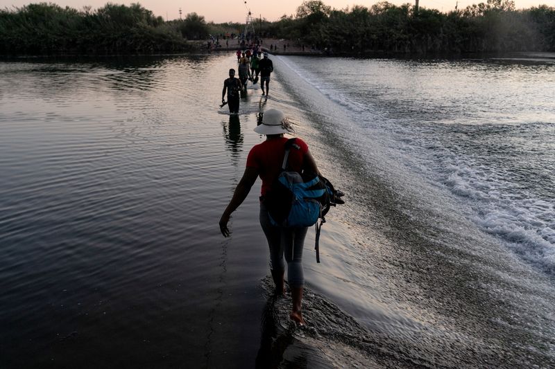 &copy; Reuters. Migrants seeking asylum in the U.S. walk in the Rio Grande river near the International Bridge between Mexico and the U.S. as they wait to be processed, in Ciudad Acuna, Mexico, September 17, 2021. Migrants cross back and forth into Mexico to buy food and