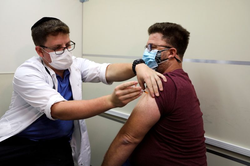 &copy; Reuters. FILE PHOTO: An Israeli man receives a third shot of coronavirus disease (COVID-19) vaccine as country launches booster shots for over 40-year-olds, in Jerusalem August 20, 2021. REUTERS/Ammar Awad