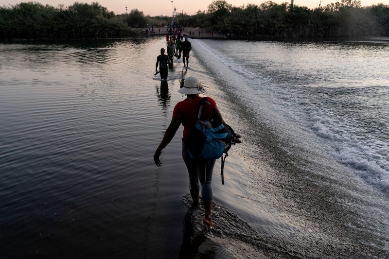 &copy; Reuters. Migrantes que buscan asilo en Estados Unidos caminan por el río Grande cerca del Puente Internacional entre México y Estados Unidos, mientras esperan ser procesados, en Ciudad Acuña, México, 17 de septiembre de 2021. Migrantes cruzan de un lado a otro