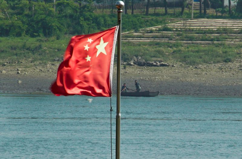 &copy; Reuters. FILE PHOTO: Two North Korean men are seen in a boat as the Chinese national flag flies over the Yalu River running between the North Korean town of Sinuiju and Dandong in China's Liaoning Province, May 25, 2018.  REUTERS/Joseph Campbell/File Photo