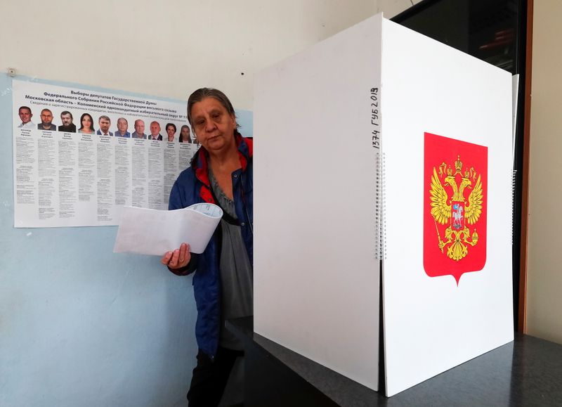 &copy; Reuters. Una mujer sale de una cabina de votación con sus papeletas en un colegio electoral durante el segundo día de una votación de tres días en las elecciones parlamentarias y regionales en el pueblo de Novoye Bobrenevo, en la región de Moscú, Rusia. 18 d