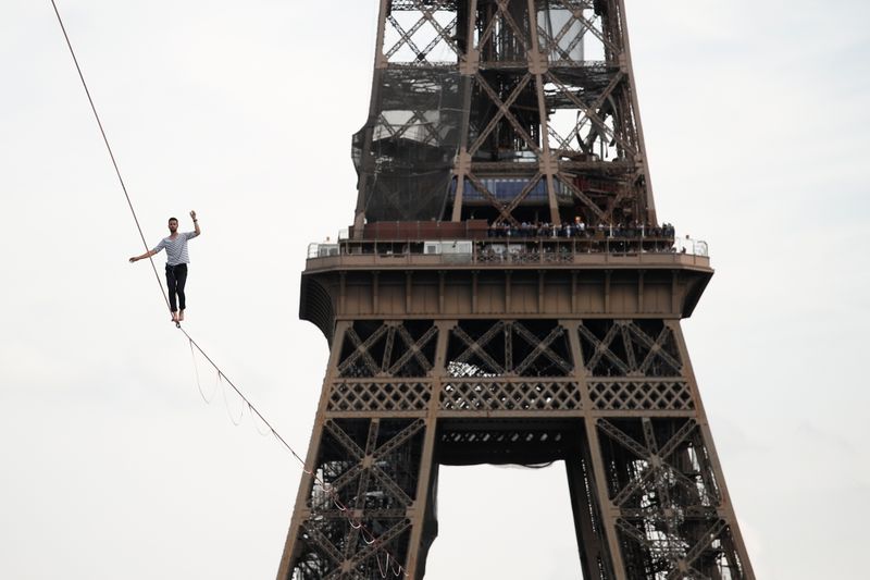 &copy; Reuters. المغامر الفرنسي ناتون بولون يمشي على حبل  مشدود بين برج إيفل ومسرح شايو على الجانب الآخر من نهر السين في العاصمة الفرنسية باريس يوم السبت. تص