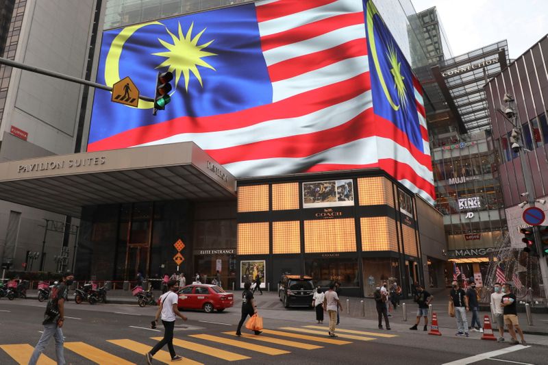 © Reuters. علم ماليزيا يظهر على شاشة كبيرة خارج متجر للتسوق في كوالالمبور يوم 6 سبتمبر أيلول 2021. تصوير:رويترز.