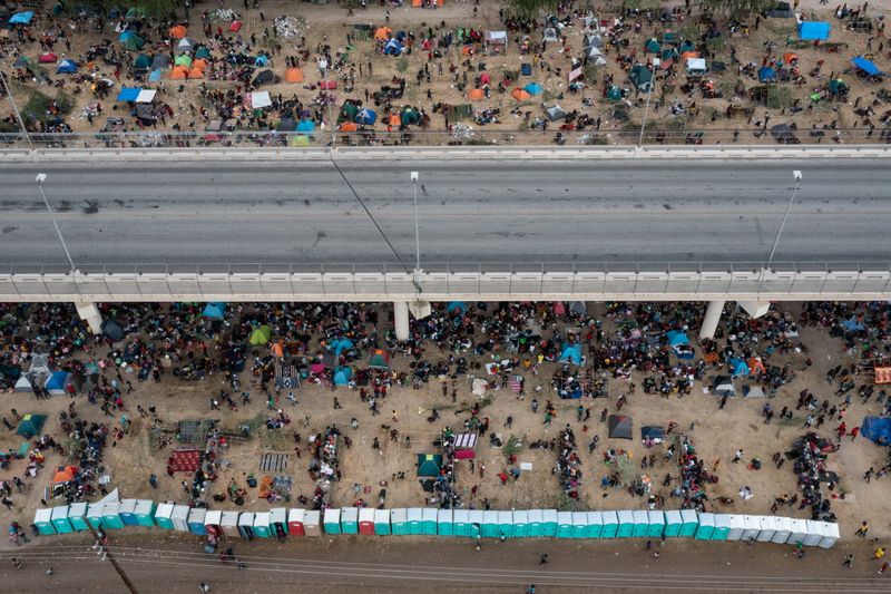 © Reuters. Some thousands of migrants take shelter as they await to be processed near the Del Rio International Bridge after crossing the Rio Grande river into the U.S. from Ciudad Acuna in Del Rio, Texas, U.S. September 18, 2021. Picture taken with a drone. REUTERS/Adrees Latif