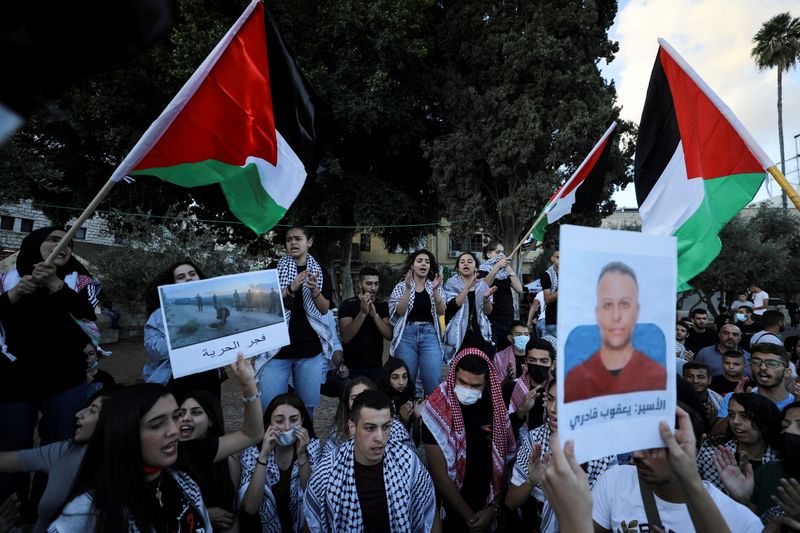 © Reuters. أشخاص يشاركون في مظاهرة لدعم سجناء فلسطينيين هربوا من سجن إسرائيلي في بلدة الناصرة بشمال إسرائيل يوم 11 سبتمبر ايلول 2021. تصوير: عمار عوض - رويترز. 