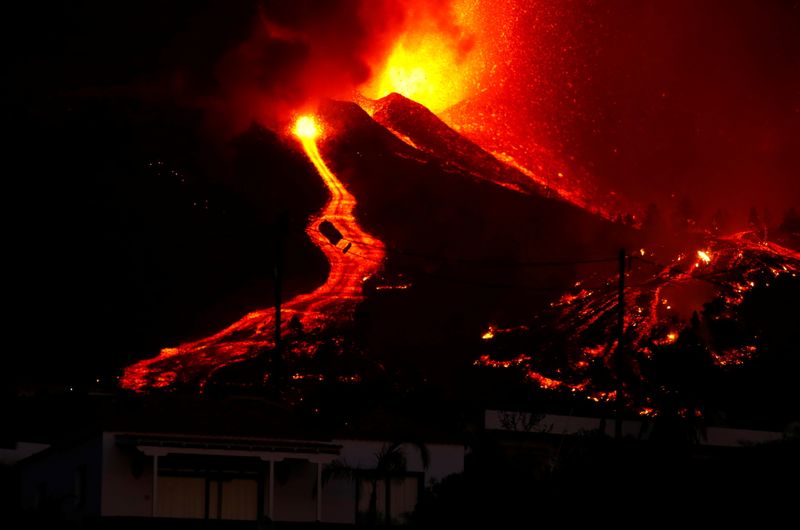 © Reuters. Flujos de lava junto a una casa tras la erupción de un volcán en el parque nacional de Cumbre Vieja en El Paso, en la isla canaria de La Palma. 19 de septiembre de 2021. REUTERS/Borja Suárez 