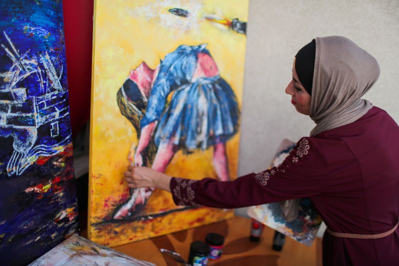 &copy; Reuters. الفنانة الفلسطينية عبير جبريل ترسم لوحة مستوحاة من فن الباليه في منزلها بغزة في صورة التقطت يوم الثامن من سبتمبر أيلول 2021. تصوير: محمد سالم - 