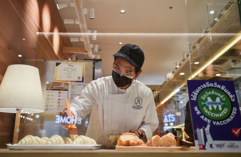 &copy; Reuters. FILE PHOTO: A staff member prepares to open a restaurant on the first day of coronavirus restrictions lift on retail and dining in Bangkok and other high-risk areas to revive the economy, as the country battles its worst coronavirus disease (COVID-19) out