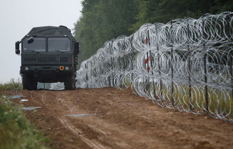 &copy; Reuters. FILE PHOTO: A view of a vehicle next to a fence built by Polish soldiers on the border between Poland and Belarus near the village of Nomiki, Poland August 26, 2021. REUTERS/Kacper Pempel/File Photo