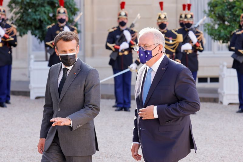© Reuters. الرئيس الفرنسي إيمانويل ماكرون يسير مع رئيس الوزراء الأسترالي سكوت موريسون في قصر الإليزيه بباريس في 15 يونيو حزيران 2021. تصوير:رويترز.