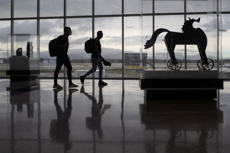 &copy; Reuters. FILE PHOTO: Passengers walk past artwork between terminals at IAH George Bush Intercontinental Airport amid the coronavirus disease (COVID-19) outbreak in Houston, Texas, U.S., July 21, 2020. REUTERS/Adrees Latif