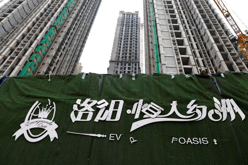 &copy; Reuters. FILE PHOTO: A peeling logo of the Evergrande Oasis, a housing complex developed by Evergrande Group, is pictured outside the construction site where the residential buildings stand unfinished, in Luoyang, China September 16, 2021. Picture taken September 