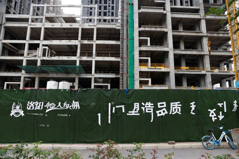 &copy; Reuters. A peeling logo of the Evergrande Oasis, a housing complex developed by Evergrande Group, is seen outside the construction site where the residential buildings stand unfinished, in Luoyang, China September 16, 2021. Picture taken September 16, 2021. REUTER