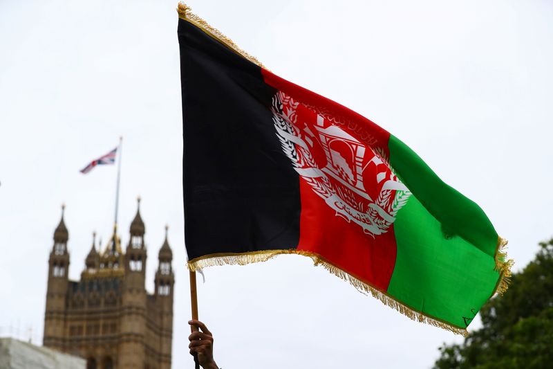 &copy; Reuters. A demonstrator holds an Afghan flag during a "Save Afghanistan" protest in Parliament Square, in London, Britain, August 17, 2021. REUTERS/Hannah McKay