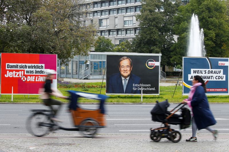 &copy; Reuters. People pass by election campaign billboards featuring Christian Democratic Union (CDU) party leader and top candidate for chancellor, Armin Laschet, and the left wing party Die Linke, in Berlin, Germany, September 20, 2021. REUTERS/Michele Tantussi