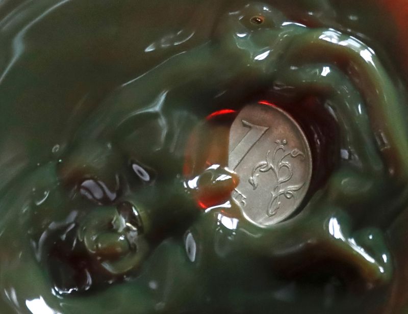 &copy; Reuters. A view shows a one Russian rouble coin inside a bulb with crude oil at a laboratory in the Yarakta Oil Field, owned by Irkutsk Oil Company (INK), in Irkutsk Region, Russia in this picture illustration taken March 12, 2019. Picture taken March 12, 2019. RE