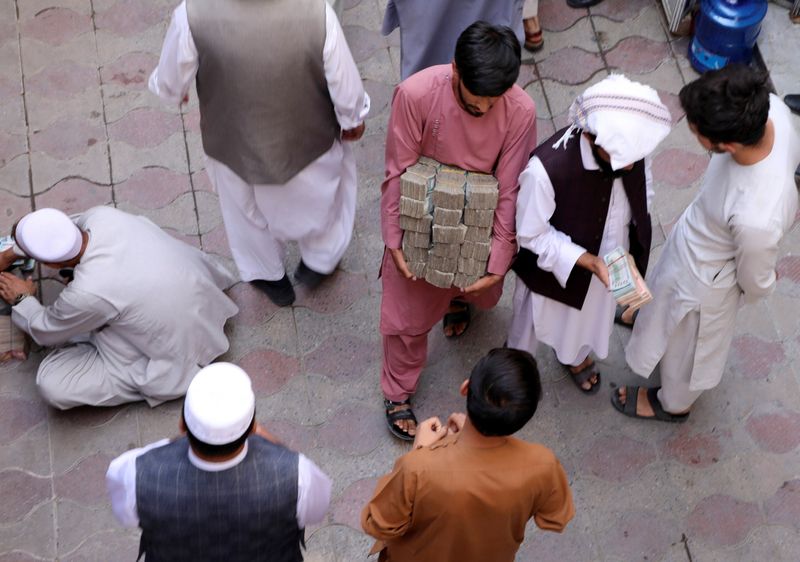 &copy; Reuters. FILE PHOTO: An Afghan money exchange dealer carries bundles of banknotes at an exchange market, following banks and markets reopening after the Taliban took over in Kabul, Afghanistan, September 4, 2021. REUTERS/Stringer/File Photo