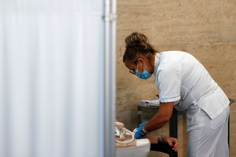 &copy; Reuters. موظفة صحة تعطي الجرعة الثالثة لقاح مضاد لكوفيد-19 في العاصمة الإيطالية روما يوم الثلاثاء. تصوير: يارا ناردي - رويترز.