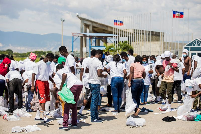 © Reuters. Haitian migrants collect their belongings after U.S. authorities flew them out of a Texas border city after crossing the Rio Grande river from Mexico, at Toussaint Louverture International Airport in Port-au-Prince, Haiti September 21, 2021. REUTERS/Ralph Tedy Erol