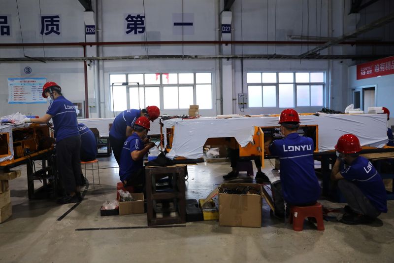 &copy; Reuters. FILE PHOTO: Employees work on assembling automated guided vehicles (AGV) at a Lonyu Robot Co factory in Tianjin, China, September 7, 2021. REUTERS/Tingshu Wang